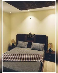 a bedroom with a bed with a checkered blanket at Full Serviced Cottage in Bhurban in Ausia