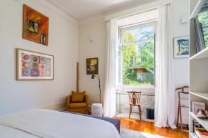 a bedroom with a bed and a window at Casa do Cativo in Porto