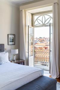 a bedroom with a bed and a large window at Casa do Cativo in Porto