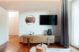 a living room with a tv and a wooden coffee table at Nockventure Apartment Nockberge in Ebene Reichenau