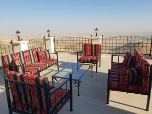 un groupe de chaises et une table sur un toit dans l'établissement Mardin tarihi ulu Cami yanı, tarihi Konak, à Mardin