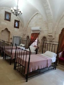 a bedroom with three beds and a chandelier at Mardin tarihi ulu Cami yanı, Kale divan konağı in Mardin