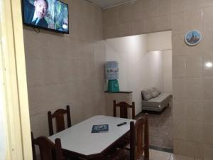a dining room with a table and a tv on the wall at Casa Vó Amélia in Aparecida