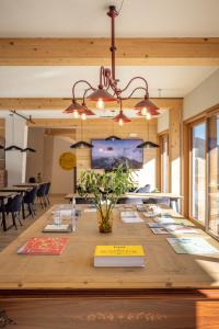 a long wooden table with books on it at Giallo Dolomiti Wellness in Pieve di Cadore