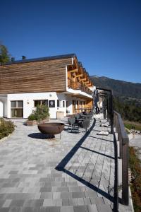 a building with a patio with chairs and a staircase at Giallo Dolomiti Wellness in Pieve di Cadore