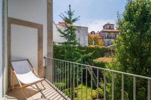 a white chair sitting on a balcony with a view at Casa do Cativo in Porto