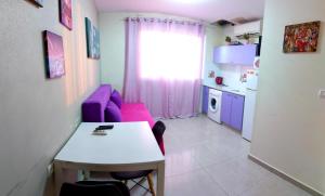 - un salon avec un canapé violet et une table dans l'établissement Beachfront Apartment Bat Yam 613, à Bat Yam