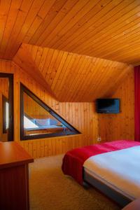 Un dormitorio con una cama en una habitación de madera. en Casa Maia, en Buşteni