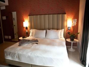 a bedroom with a large white bed with two lamps at Hotel L'Approdo in Pettenasco