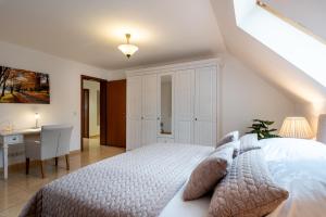 a bedroom with a white bed and a desk at Ferienwohnung im grünen Mühlenbeck-nahe Berlin in Mühlenbeck