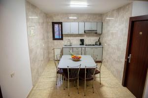 Una cocina y un comedor con mesa y sillas. en Casa Maia, en Buşteni