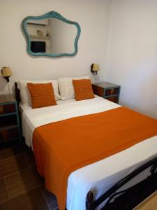a bedroom with a large bed with an orange blanket at Stone Wasi in Montevideo