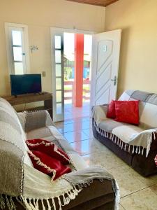 a living room with two beds and a sliding door at Apartamentos Vitali in Imbé