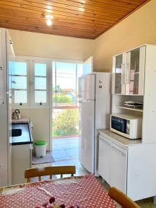 cocina con electrodomésticos blancos y ventana grande en Apartamentos Vitali en Imbé