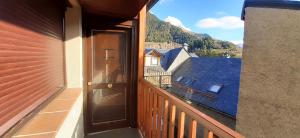 a balcony with a door and a view of a building at Apartamento centro de Sallent con WIFI in Sallent de Gállego