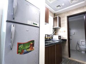 a kitchen with a refrigerator with a picture on it at Barsha Star Residence - Home Stay in Dubai