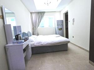 a small bedroom with a bed and a mirror at Barsha Star Residence - Home Stay in Dubai