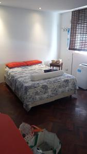 a bedroom with a bed with a blanket and a table at Cozy studio in Palermo, Las Cañitas 300MB in Buenos Aires
