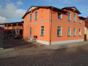 an orange building with a car parked in front of it at Haus No. 5A in Demmin