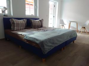 a blue bed with a blue comforter and pillows at Haus No. 5A in Demmin