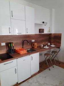 a kitchen with white cabinets and a sink at Apartman White Wings Bjelasnica in Bjelašnica +25 photos