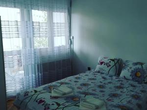 1 Schlafzimmer mit einem Bett mit Blumenbettdecke in der Unterkunft Apartman Caroline in Čačak
