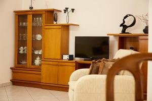 sala de estar con TV de pantalla plana y silla en APARTMENT in XANTHI My home, en Xanthi