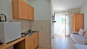 a kitchen with a white refrigerator and a couch at MM Apartments in Budva