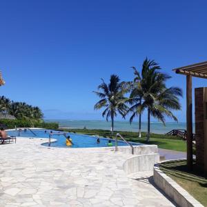 a pool at the beach with people in it at Casa Encanto dos Milagres in São Miguel dos Milagres