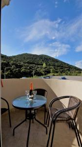 a table with two chairs and a bottle of wine on a balcony at MM Apartments in Budva +31 photos