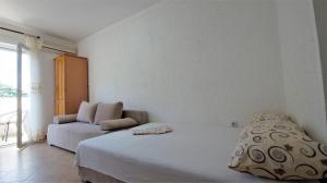 a white bedroom with a bed and a couch at MM Apartments in Budva