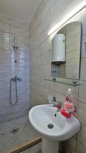 a bathroom with a sink and a shower and a mirror at MM Apartments in Budva