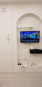 ein Wohnzimmer mit einem TV an der Wand in der Unterkunft HOLIDAY HOUSE FIERAVECCHIA in Salerno
