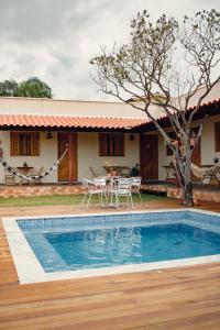 a villa with a swimming pool in front of a house at Vila Bonita in Alto Paraíso de Goiás