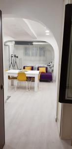 a dining room with a white table and yellow chairs at HOLIDAY HOUSE FIERAVECCHIA in Salerno