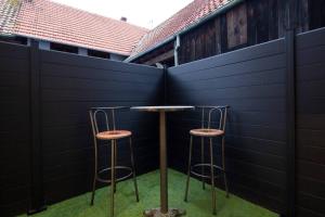 een tafel en twee krukken voor een hek bij Le Logis d'Alsace, Wifi,TV,Parking,70 m2 in Ettendorf
