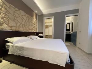 Un dormitorio con una cama grande con una pared de piedra. en Al Piano 2, en Ancona