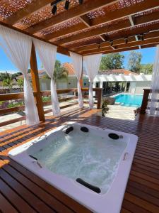 a hot tub on a deck next to a pool at Pousada Saint Diniz in Monte Sião