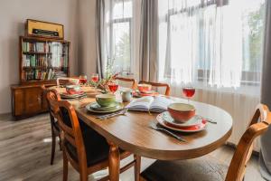 a dining room table with chairs and a wooden tableablish at Villa 124 SPA & Sauna komfortowy apartament Beskidy in Bystra