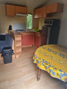 a small kitchen with a bed in a room at Camping de la mothe in Banassac