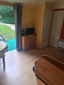 a living room with a large sliding glass door at Camping de la mothe in Banassac