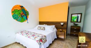 een slaapkamer met een bed met een papegaai aan de muur bij Bosques de la Pradera in Manizales