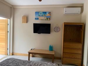 ein Wohnzimmer mit einem TV und einem Holztisch in der Unterkunft Hotel Las Palmas de OSA in Ciudad Cortés