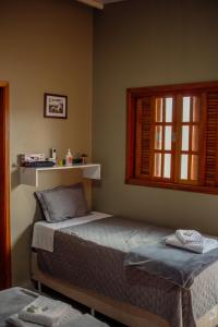 - une chambre avec 2 lits et une fenêtre dans l'établissement Vila Bonita, à Alto Paraíso de Goiás