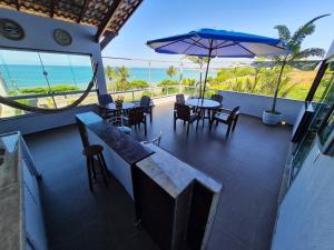 a patio with a table and chairs and an umbrella at Frente para o Mar MEAIPE in Guarapari