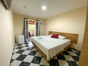 a bedroom with a bed and a checkered floor at Leviv Praia Hotel in Caraguatatuba
