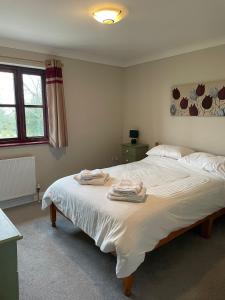 a bedroom with a large bed with towels on it at Rose Cottage in Camelford