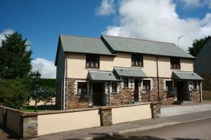 une grande maison en briques avec un toit noir dans l'établissement Rose Cottage, à Camelford