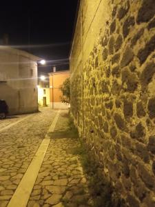 a stone wall next to a street at night at L'altra casa 1933 in Rionero in Vulture