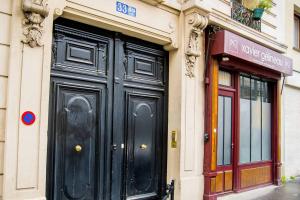 a black door on the side of a building at Studio boisé à 2 pas du jardin du Luxembourg in Paris
